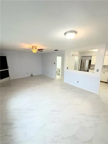 Unfurnished living room with ceiling fan and light tile patterned floors