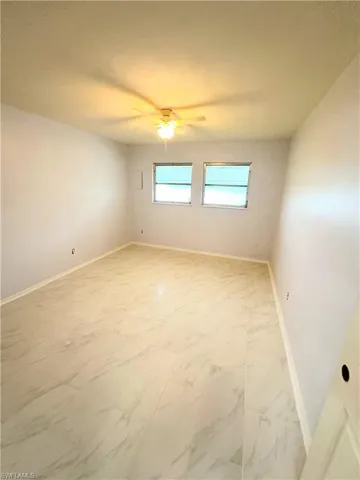 Tiled empty room with ceiling fan