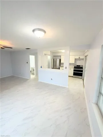Unfurnished living room with ceiling fan and light tile patterned floors