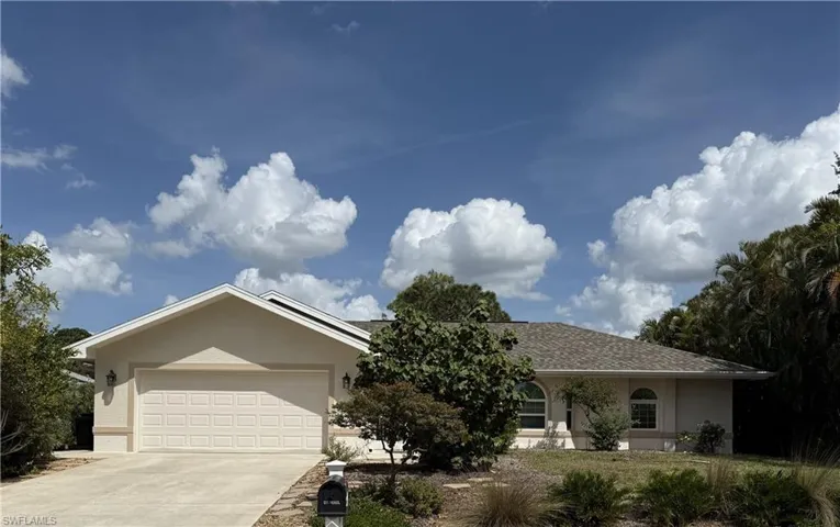 Ranch-style house with a garage, roof with shingles, driveway, and stucco siding