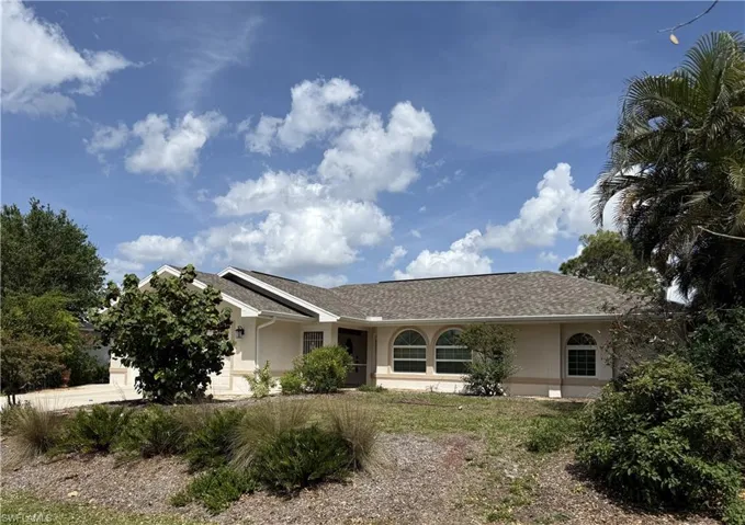 Single story home featuring roof with shingles, stucco siding, an attached garage, and driveway