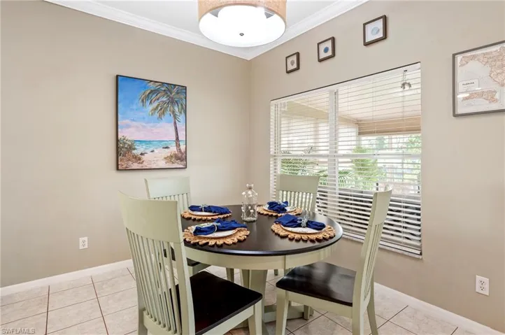 Dining area featuring crown molding and light tile patterned flooring
