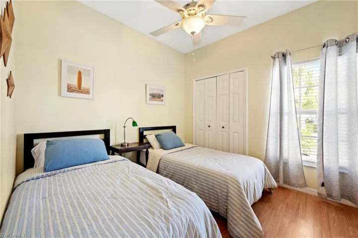 Bedroom with a closet, wood finished floors, and a ceiling fan