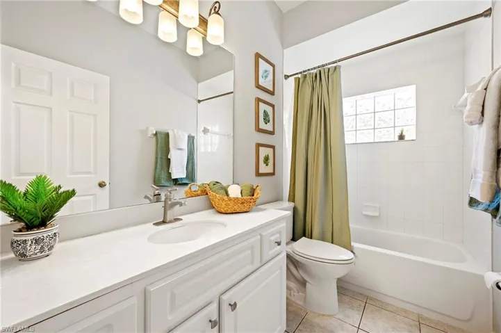 Bathroom featuring vanity, tile patterned flooring, and shower / bath combo with shower curtain