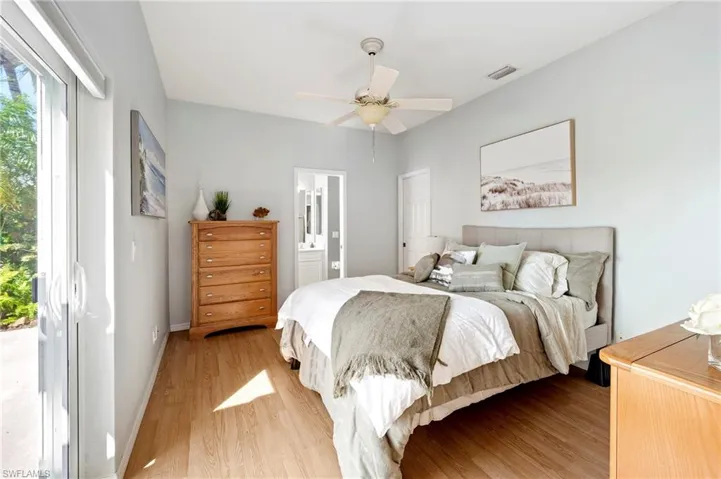 Bedroom with light wood finished floors, multiple windows, access to outside, and ceiling fan