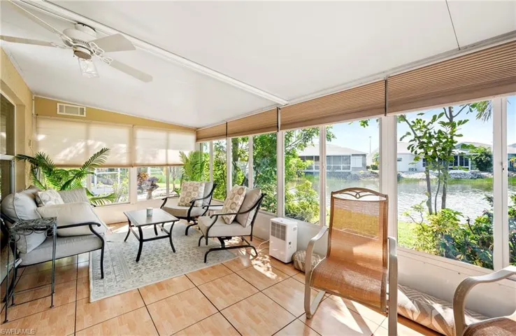Sunroom / solarium with a water view, plenty of natural light, vaulted ceiling, and ceiling fan