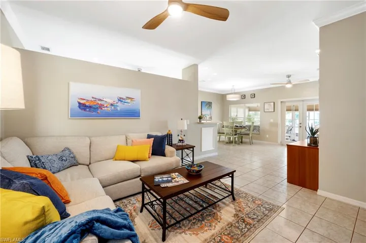 Living area featuring a ceiling fan, light tile patterned floors, ornamental molding, and recessed lighting