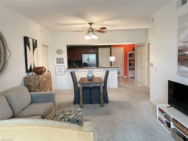 Carpeted living room featuring ceiling fan