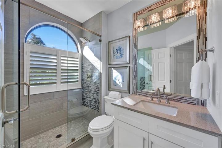 Guest bath features a detailed walk-in shower and quartz countertops.