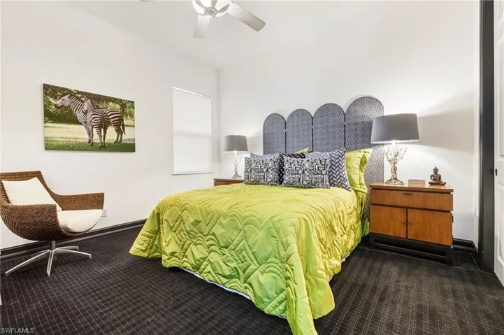 Bedroom with dark colored carpet and a ceiling fan