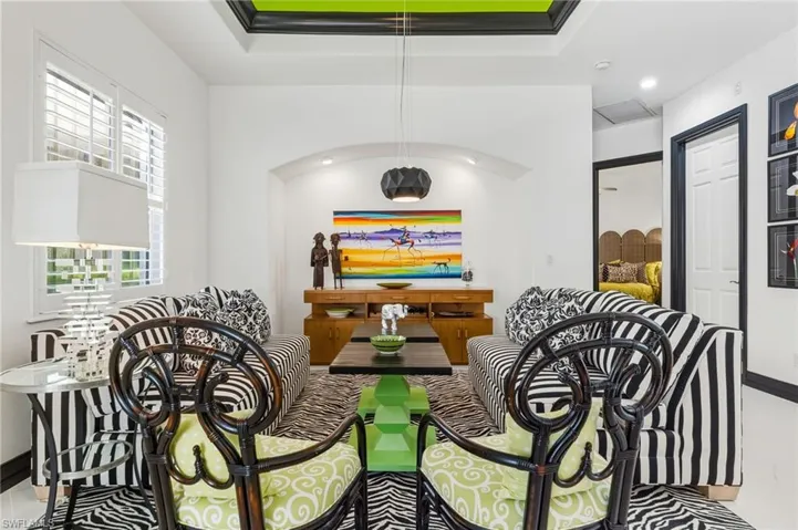 Dining area with a tray ceiling, light tile patterned flooring, and recessed lighting