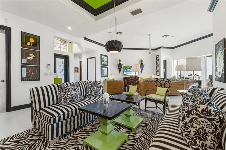 Living area with arched walkways, crown molding, and recessed lighting