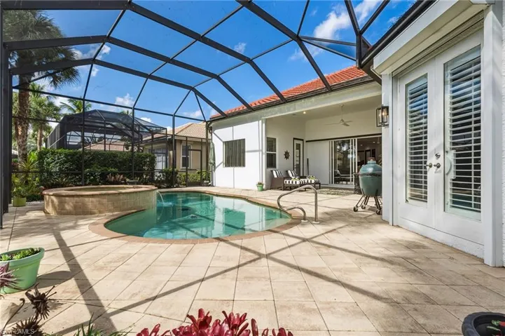 View of swimming pool featuring a sunroom, a ceiling fan, a pool with connected hot tub, a patio, and a lanai