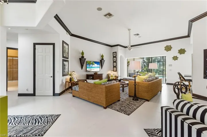 Living area featuring ornamental molding and ceiling fan