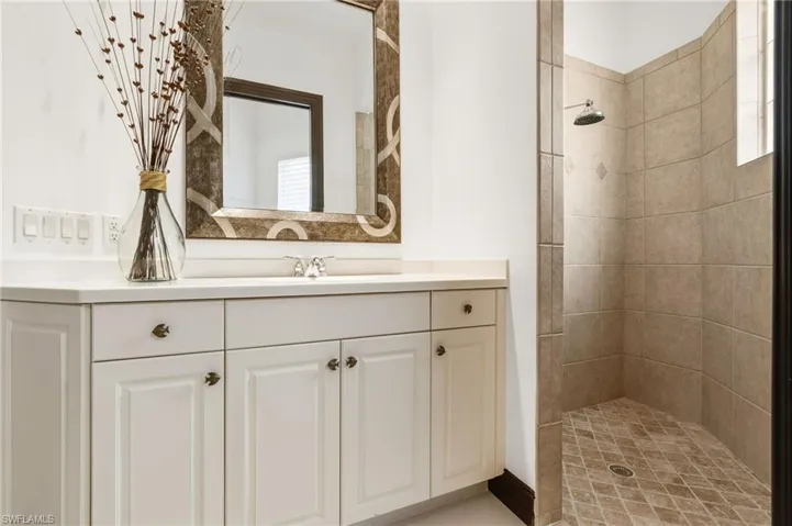 Bathroom with vanity and a tile shower