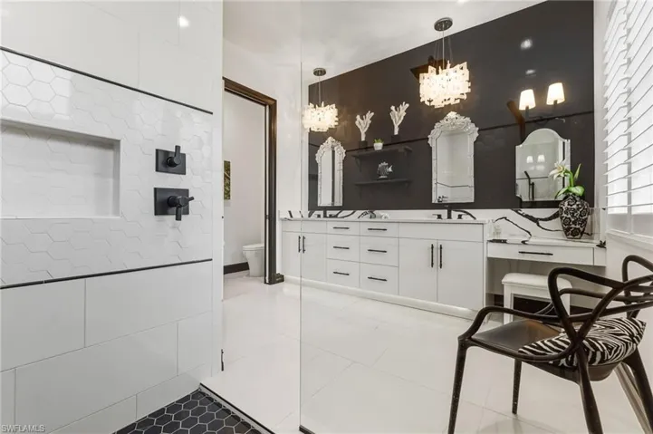 Bathroom featuring double vanity, light tile patterned floors, and a chandelier