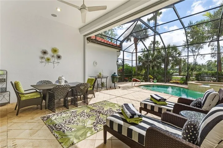 View of patio / terrace with a sunroom, a pool with connected hot tub, ceiling fan, and glass enclosure