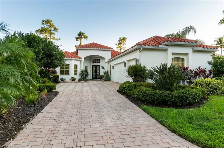 Mediterranean / spanish home featuring stucco siding, french doors, decorative driveway, a garage, and a tiled roof