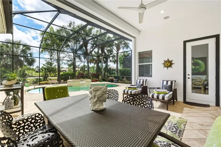 View of patio with a pool with connected hot tub, a sunroom, a lanai, ceiling fan, and outdoor dining space