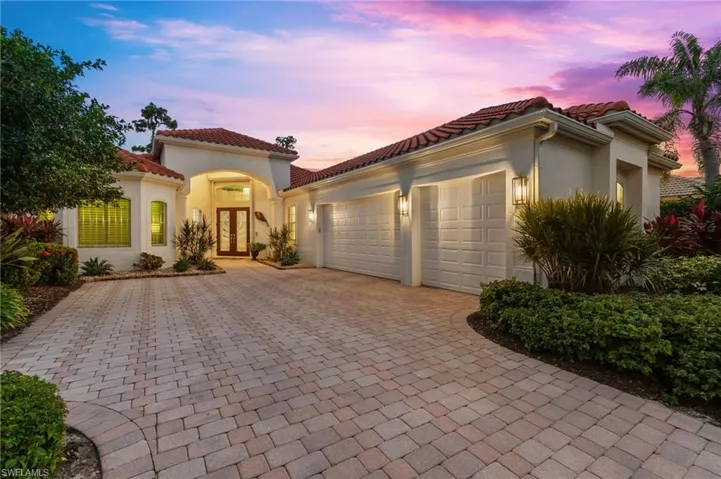 Mediterranean / spanish-style house featuring french doors, a garage, decorative driveway, stucco siding, and a tiled roof