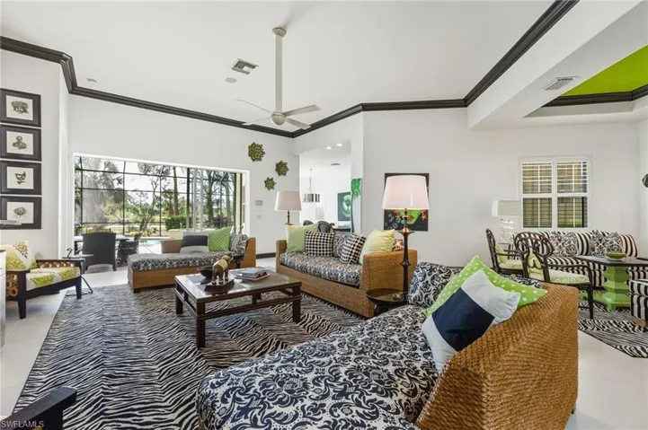 Tiled living area with ornamental molding and a ceiling fan