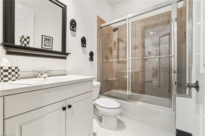 Bathroom featuring shower / bath combination with glass door and vanity