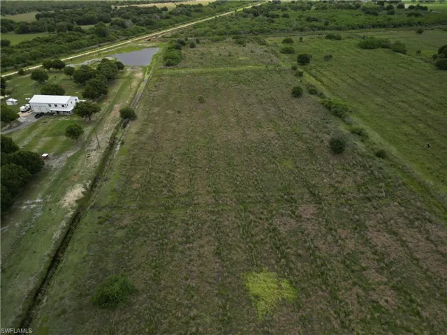 Expansive verdant acreage featuring a private pond and a single-story building
