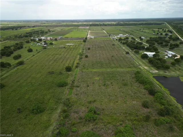 Expansive aerial view of substantial land parcel featuring diverse vegetation and cultivated fields