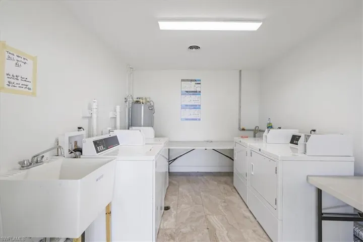 Shared laundry room with washing machine and clothes dryer and electric water heater