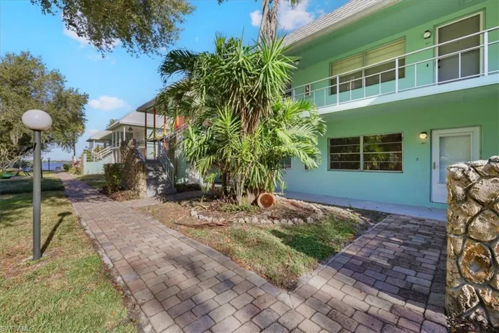View of home's exterior featuring stucco siding, a balcony, and a yard