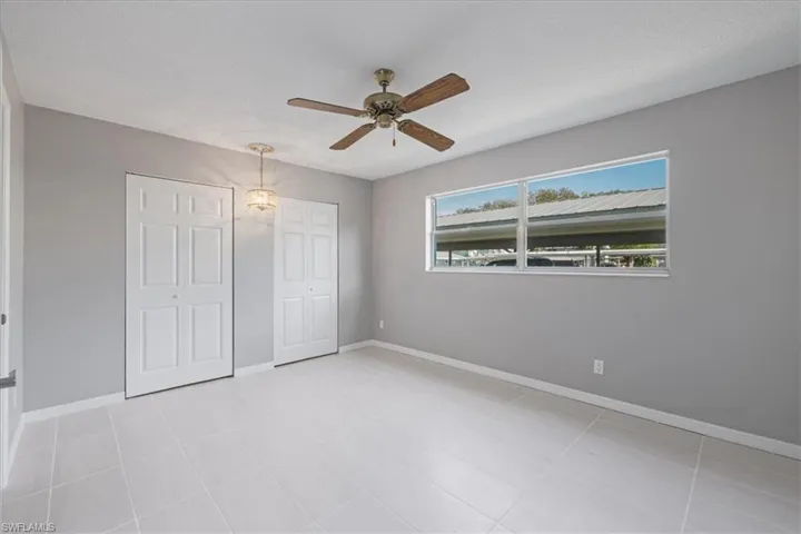 Unfurnished bedroom featuring two closets and a ceiling fan