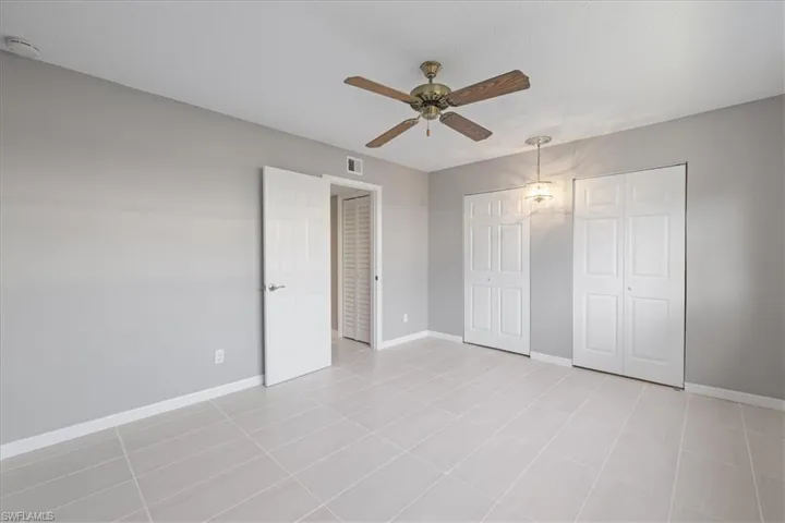 Unfurnished bedroom featuring ceiling fan and light tile patterned floors