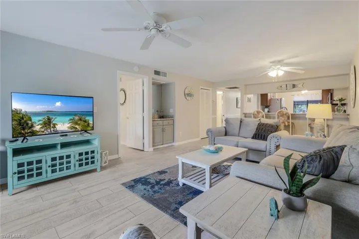 Living room with a ceiling fan and light wood-type flooring