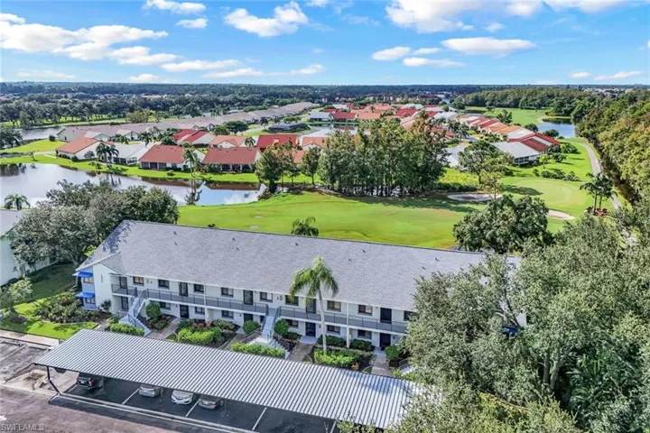Aerial view of residential area with a golf club and a large body of water