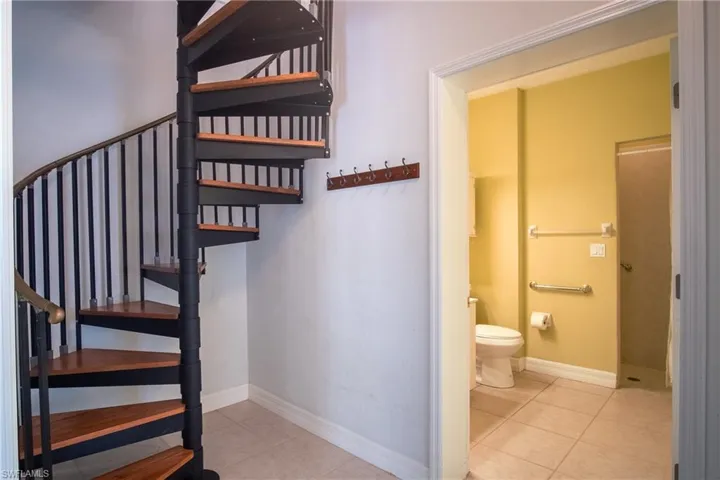 Downstairs primary bathroom & spiral staircase