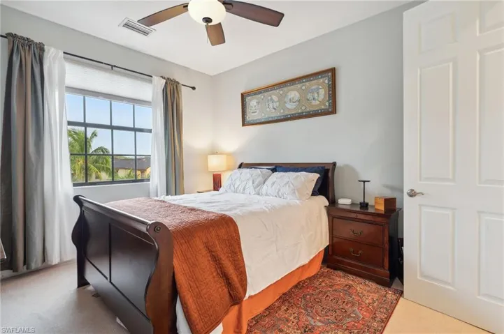 Bedroom with ceiling fan and light carpet