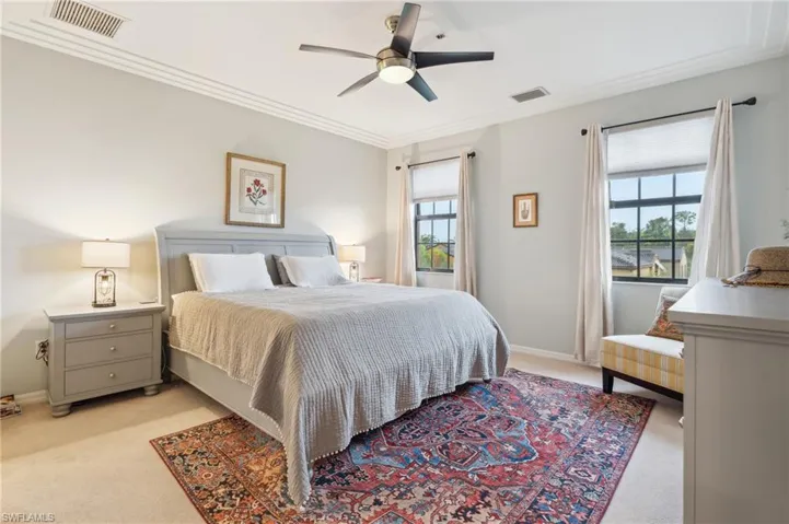Bedroom with crown molding, ceiling fan, and light carpet