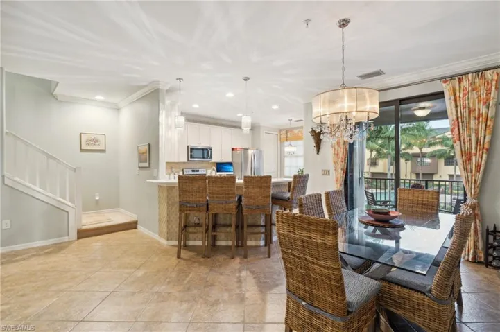 Dining room featuring ornamental molding, light tile patterned floors, and a chandelier