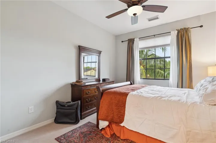 Bedroom with ceiling fan and light carpet