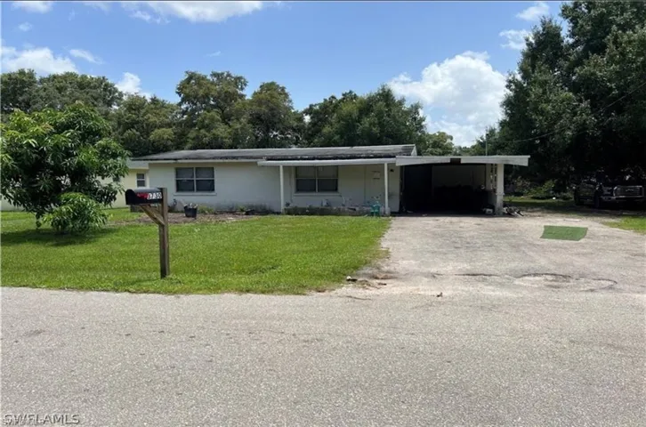 Ranch-style house with a front lawn and a carport