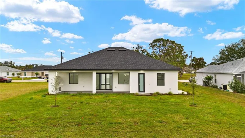 Back of house featuring spacious lanai, entry to full bath. Room for a pool.