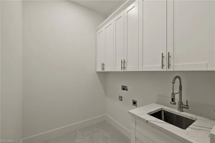 Laundry room featuring  42" cabinets, sink with cabinet and quartz counter top. Washer & Dryer Included