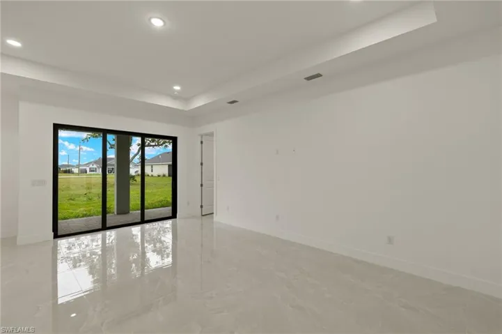 Living room with impact resistant sliding doors, tray ceiling