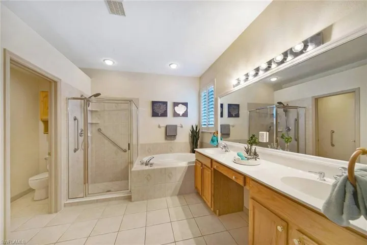Full bathroom featuring tile patterned floors, vanity, plus walk in shower, and toilet