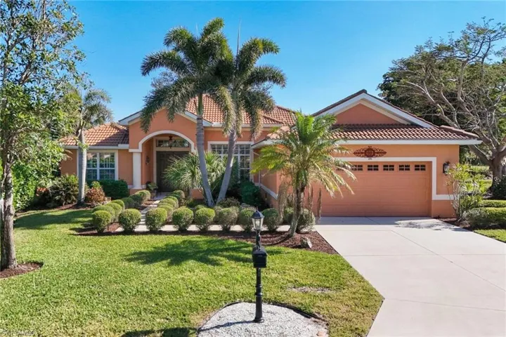 Mediterranean / spanish home featuring a garage and a front lawn