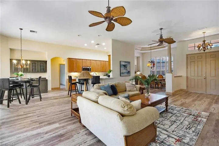 Living room featuring light hardwood / wood-style floors and ceiling fan with notable chandelier