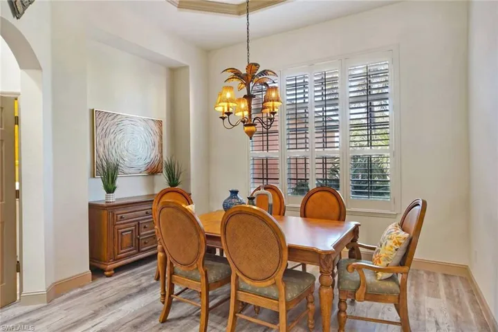 Dining room with an inviting chandelier, a healthy amount of sunlight, and light hardwood / wood-style floors