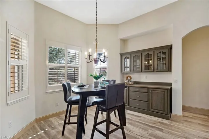 Dining space with a notable chandelier and light wood-type flooring