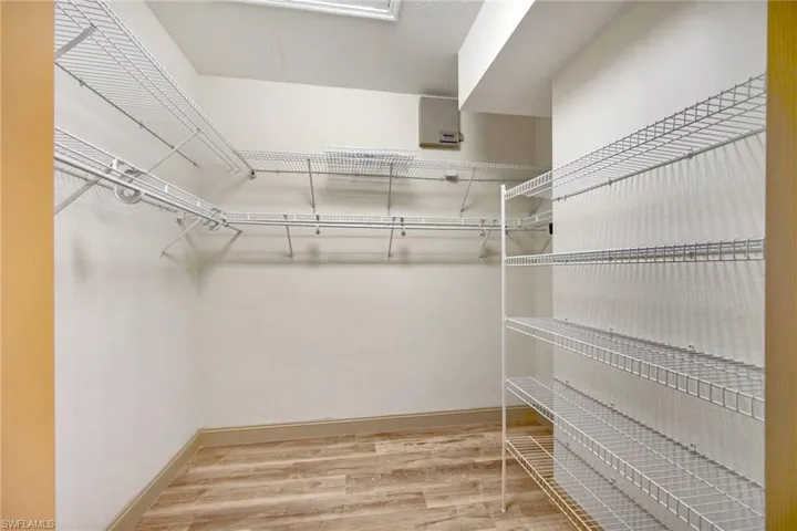 Spacious closet with hardwood / wood-style flooring