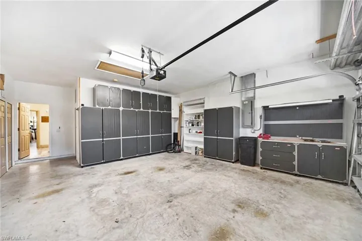 Garage featuring electric panel and a garage door opener